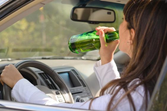 Driver holding a green bottle
